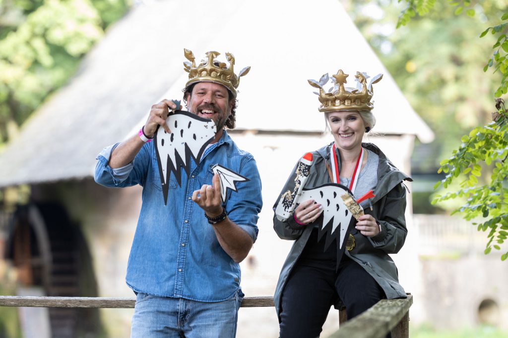 1 Mann & 1 Frau (Mitarbeiter MEDIAHAUS) bei einem Event der Firma. Beide haben eine mit luftgefüllte Krone auf und einen kaputten Styroporvogel.