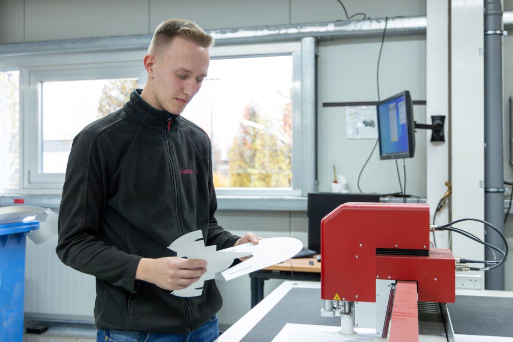 Mitarbeiter steht an einer Maschine aus dem Paxkaging Solution