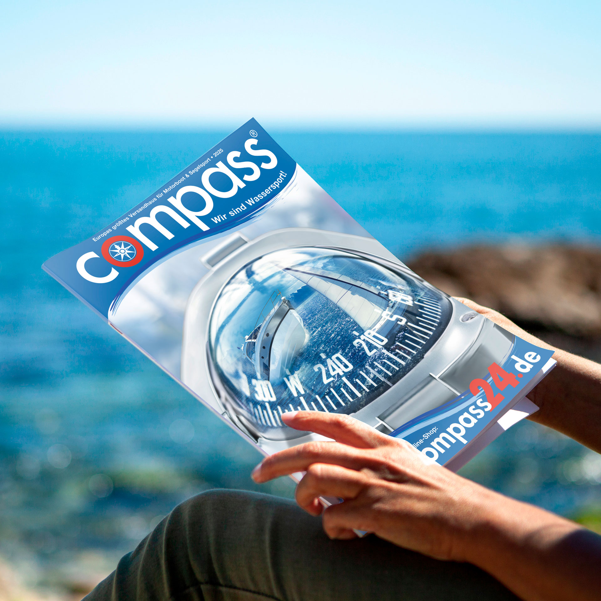 Person hält Refereznkatalog von Compass in der Hand.