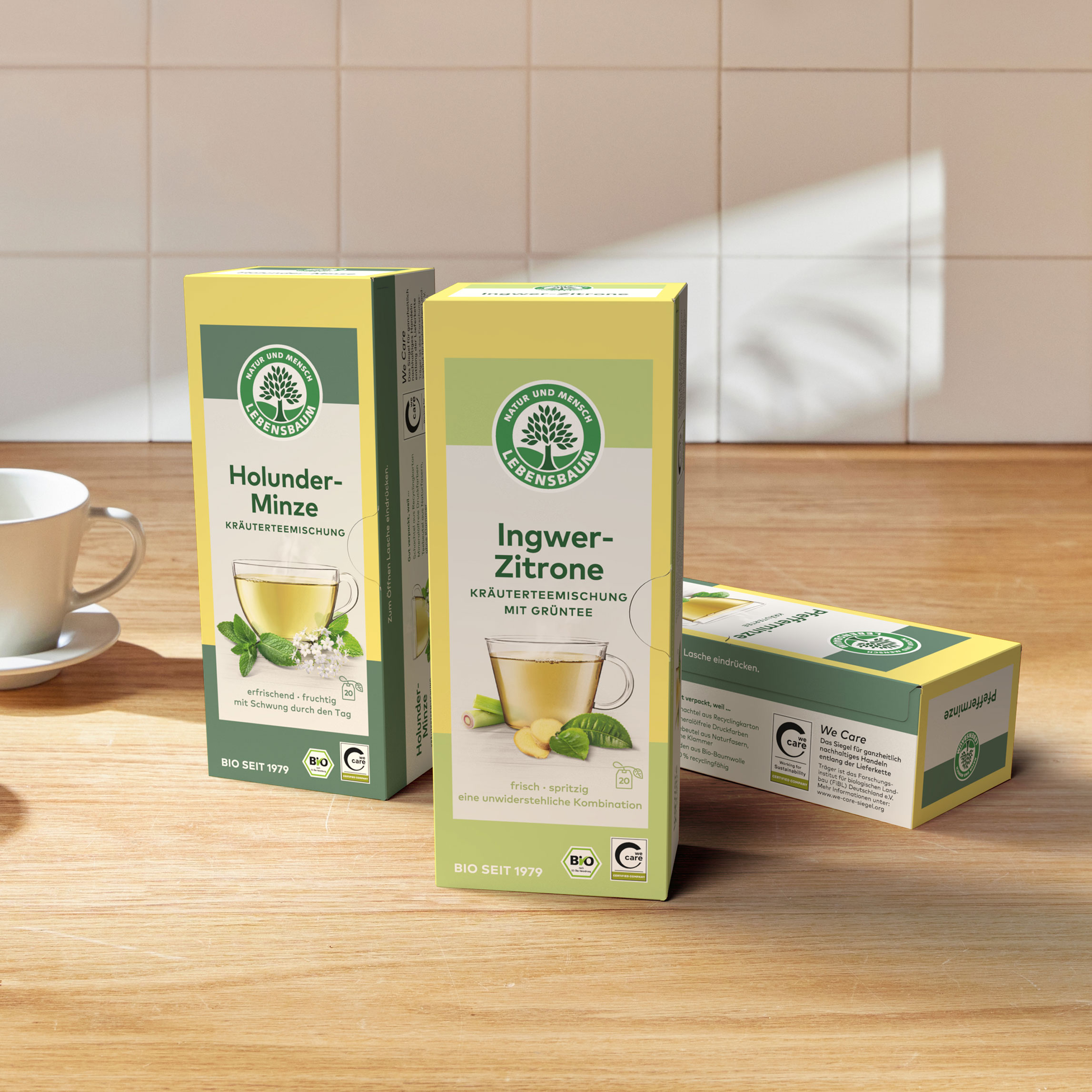 Referenz Faltschachteln mit dem Logo "Natur und Mensch Lebensbaum" für Tee. Die Verpackung ist gleb, grün und weiß.