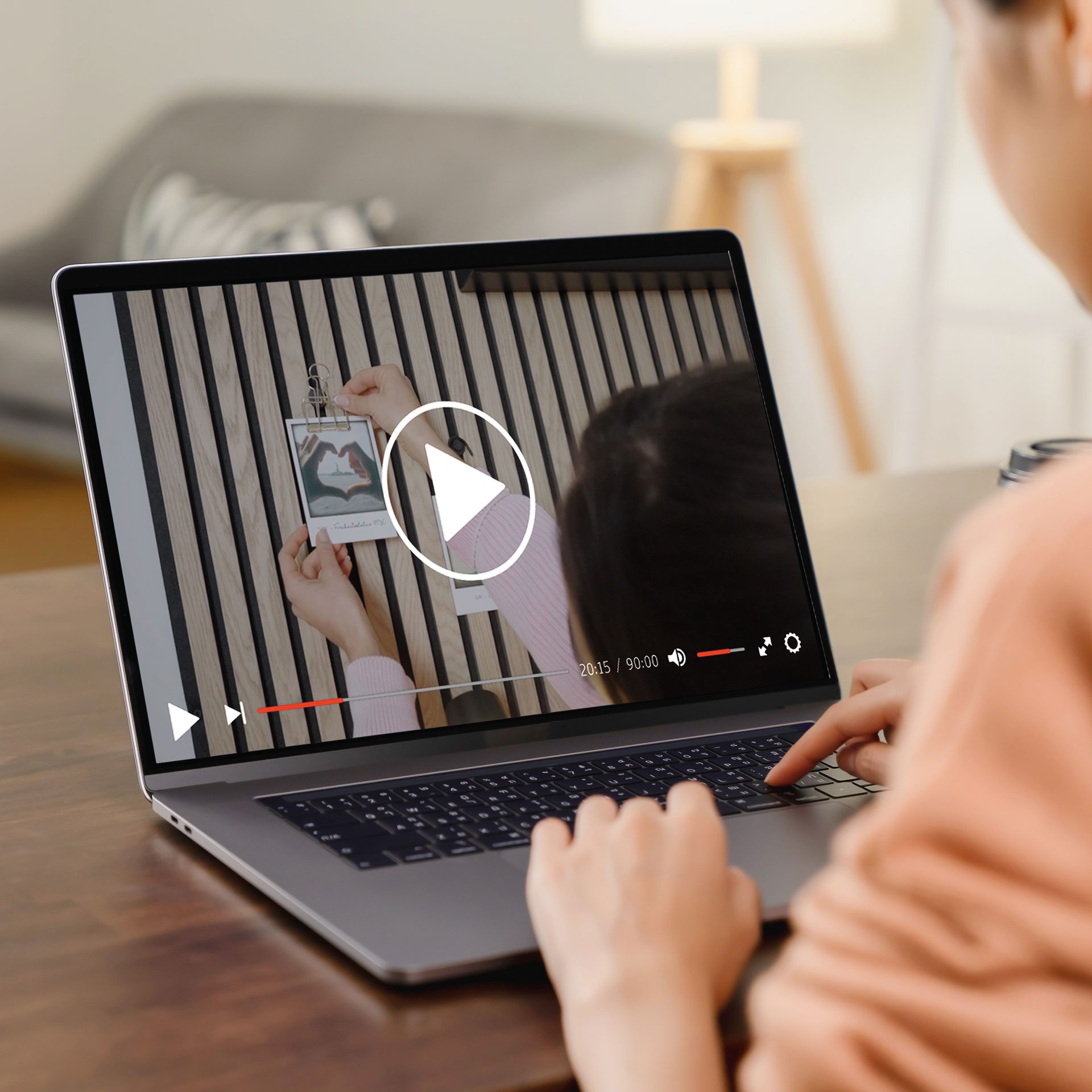Person sitzt an einem Tisch mit einem Laptop. Auf dem Laptop ist ein Video über die Living-Wall von Ter Huerne zu sehen.
