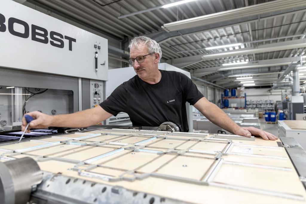 Mitarbeiter aus der Druckerei an einer Durckereimaschine